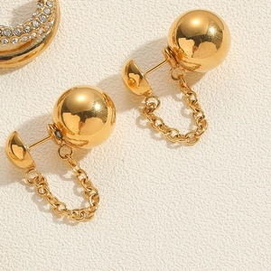 Macro detail of 18K gold-plated tassel earrings with zirconia inlay and mirror polish