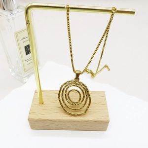 Detail view of a 18K gold-plated necklace with triple irregular ring pendants on a display