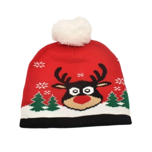 Detail of red Christmas knit hat featuring a reindeer pattern and white fluffy pompom