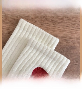 Gros plan sur les revers côtelés blancs de chaussettes en coton à haute élasticité et logo