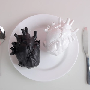 Artistic anatomical heart ceramic vase in black and white displayed on a dining plate