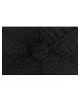 Close-up of black cotton baseball cap top showing detailed stitching and fabric texture