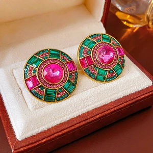 Macro detail of vintage round stud earrings with pink and green stones in a gift box