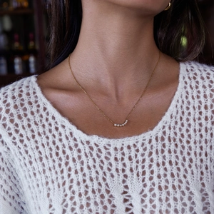 Close-up of elegant 18K gold plated stainless steel necklace with pearl smile pendant