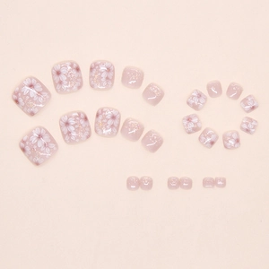 Detail of pink rose mist toe nail patches with white floral patterns and fine gold glitter