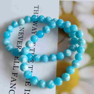 Detail of 8mm light blue cat-eye stone bracelet with natural white textures and smooth beads