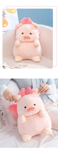 Detailed view of pink piggy plush toy with bow and wings on a beige sofa