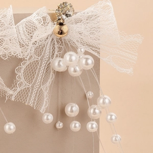 Vue détaillée de boucles d'oreilles nœud en dentelle avec perles et strass brillants