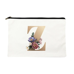 Detailed close-up of a white canvas makeup bag featuring a floral gold letter Z and zipper