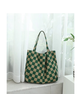 Close-up of green checkered canvas tote bag with a focus on fabric texture and pattern