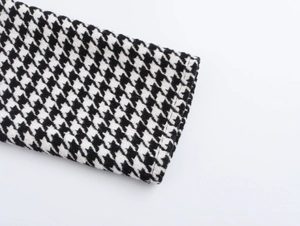 Vue macro du poignet de la robe en maille pied-de-poule noir et blanc avec coutures