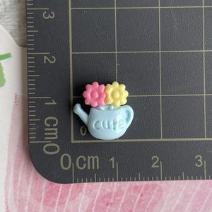 Mini resin watering can charm with flowers for DIY crafts, measures 1.3cm on a grid scale