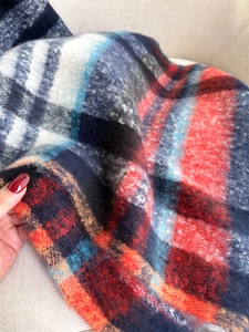 Close-up of red and blue plaid scarf showing fuzzy texture and classic tartan pattern