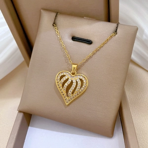 Close-up of a gold heart pendant with crystal pavé in a cream jewelry box