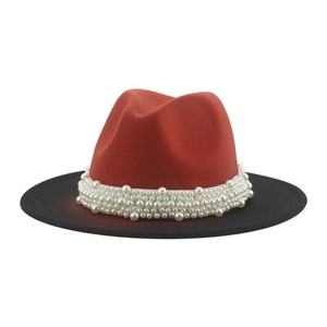 Detail of red and black felt fedora hat featuring multiple rows of elegant white pearls