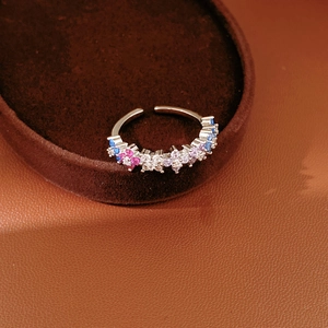 Detail of adjustable silver ring featuring colorful zircon flower clusters in a macro shot