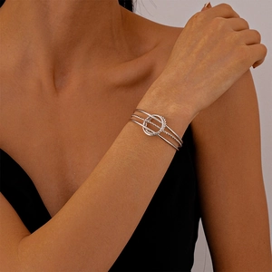 Detailed view of silver triple-layered geometric cuff bracelet with intertwined rings