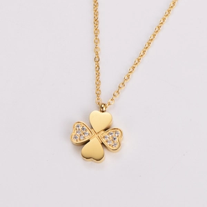 Close-up of golden four-leaf clover necklace pendant with sparkling zircon inlays