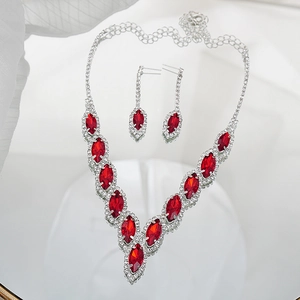 Close-up of bridal jewelry set with red marquise crystals and silver chain on mirror