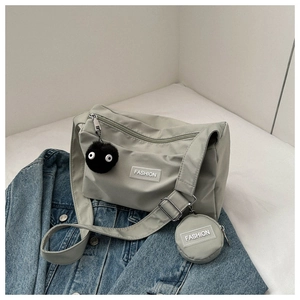 Détail du sac bandoulière en nylon gris avec mini pochette et porte-clés en fourrure