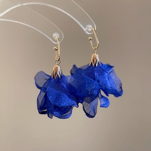 Detailed close-up of blue chiffon flower earrings with gold hollowed metal caps