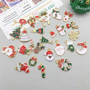 Close-up of assorted enamel Christmas charms including Santa, elk, and trees for DIY jewelry