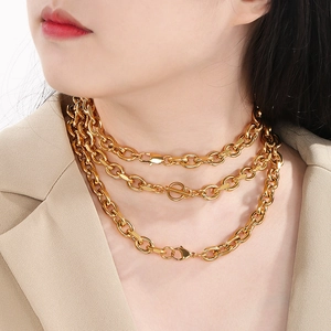 Three-layer golden OT buckle necklace in stainless steel on a model with beige suit