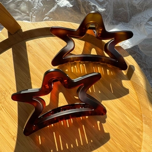 Set of two large 11cm star-shaped hair clips in dark amber resin with elegant matte finish