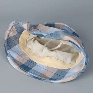 Detail of plaid bucket hat interior showing adjustable strap and beige fabric lining