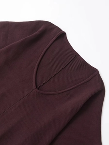 Dettaglio della maglia a coste viola scuro con scollo a V pulito e trama raffinata