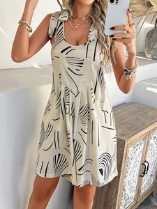 Close-up of bohemian mini dress with black abstract print on beige fabric worn by woman