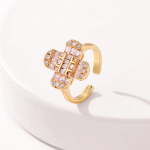 Macro shot of gold cross ring with cubic zirconia on a white display stand