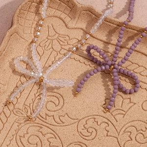 Detailed shot of clear and purple crystal beaded necklaces with golden accents on a plate