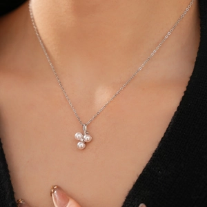 Close-up of geometric round pearl necklace with zircon accents on a female neck