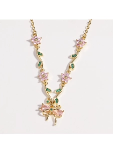Detail der Goldkette mit rosa Blume und Schleifenanhänger mit Kristallbesatz