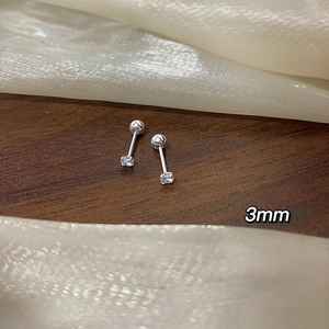Detail of 3mm cubic zirconia stud earring with screw back on a textured wooden background