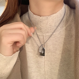 Silver titanium steel necklace with rectangular leaf engraved pendant worn by a model