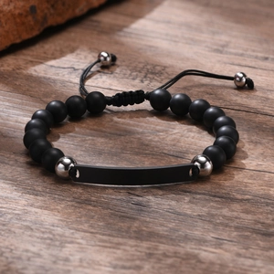 Detail eines Armbands aus mattschwarzem Onyx mit anpassbarem Metallsteg auf Holz