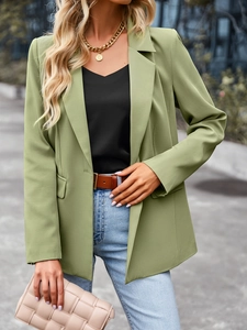 Detail of short-sleeved green blazer showing patchwork design and professional tailored fit