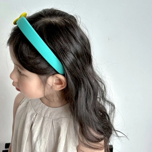 Side view of a girl wearing a sweet cyan sponge headband with smooth fabric texture