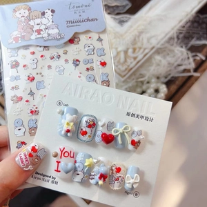 Detail of 3D embossed bear and bow nail stickers on light blue and white press-on nails