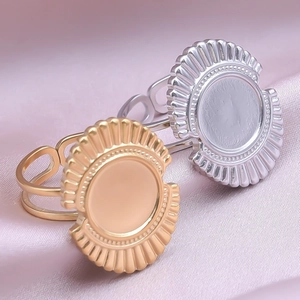 Macro view of adjustable gold and silver sunburst rings on soft silk fabric