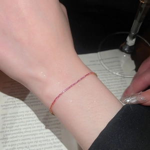 Close-up of elegant gold bracelet with sparkling pink zircons on a vintage book page