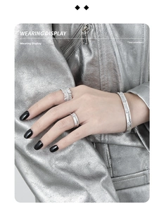 Detail of silver S925 cuff bracelet and star embossed rings with matte frosted texture