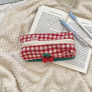 Close-up of red and white checkered plush pencil case with cute cherry charm