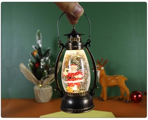 Close-up of vintage bronze Christmas snow globe lantern with Santa Claus and warm LED light