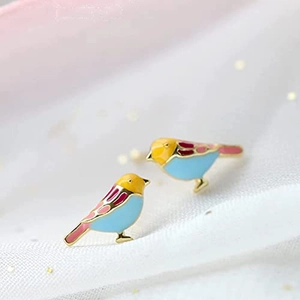 French style bird stud earrings with colorful enamel and golden edges on white fabric