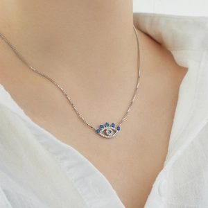 Close-up of S925 sterling silver evil eye necklace with blue and white stones on neck