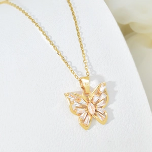 Close-up of a gold butterfly pendant necklace with inlaid zircon crystals and hollow design