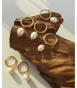 Detail shot of three pairs of vintage 18K gold plated hoop earrings with white pearls